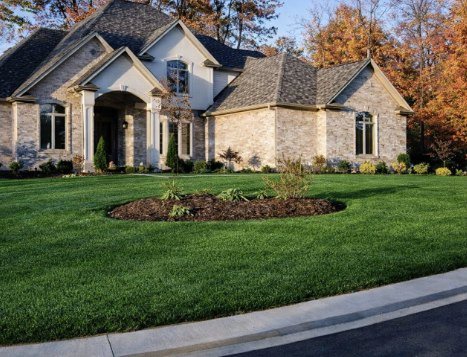 Belmont, a light stone French country custom home with an arched entry