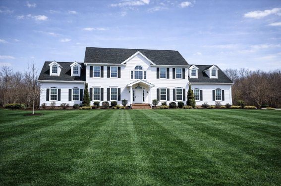 Ellington, a white colonial estate home with dormers and black shutters