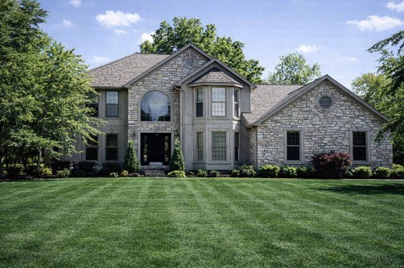 Stonebridge, a stone two-story custom home with an arched transom window