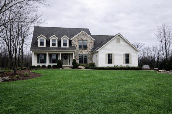 Stratford, a stone and white siding cape with three dormers and a front porch